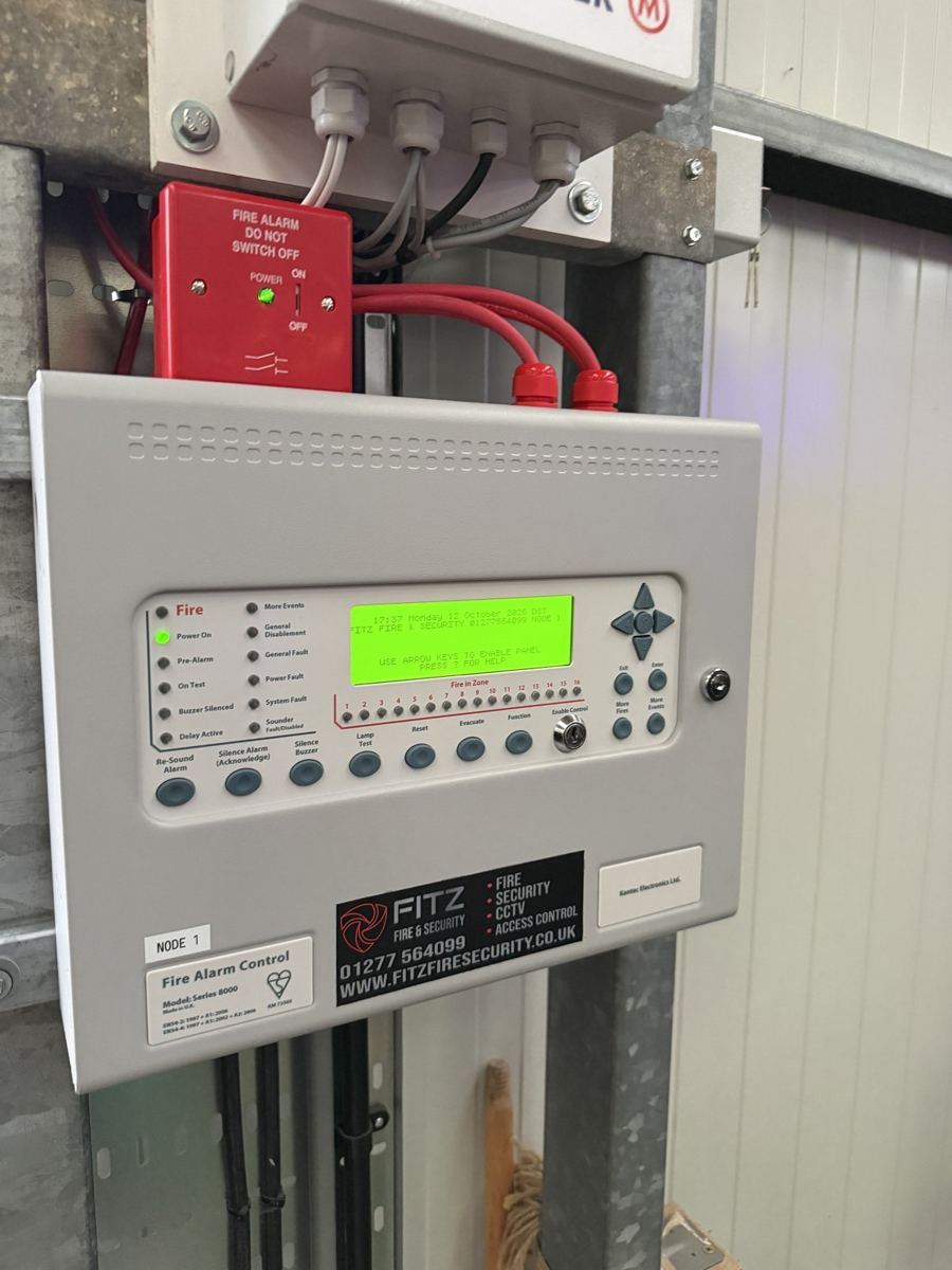 Fire alarm control panel with a FITZ FIRE & SECURITY service label and isolator above